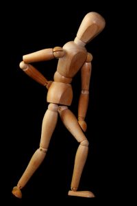 Image of a wooden figure with back pain needing treatment